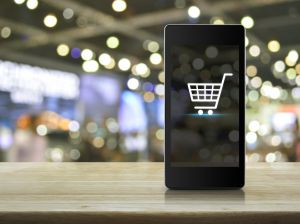 Icône de panier d'achat sur l'écran d'un téléphone intelligent dans un centre commercial flou